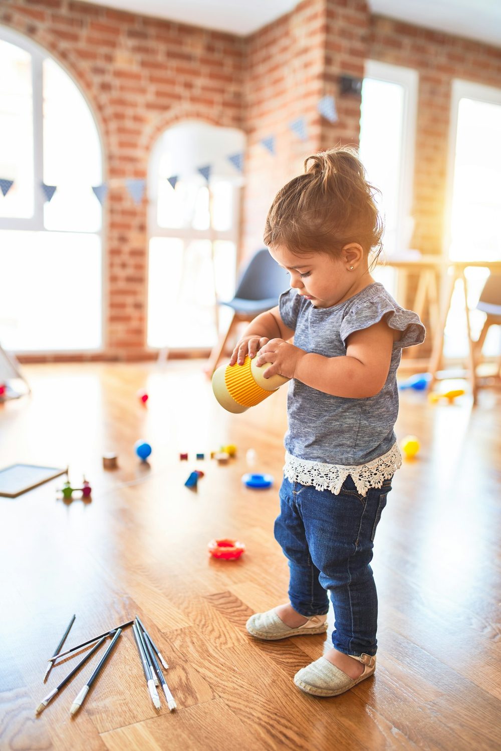 A toddler playing happily in a sunlit home